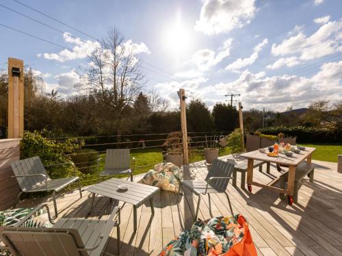 une terrasse en bois avec une table de pique-nique et des chaises. dans l'établissement Holiday Home L'évasion Nordique by Interhome, à Plouër-sur-Rance