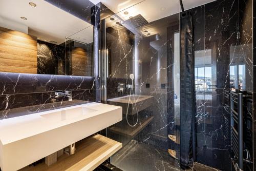une salle de bain avec un lavabo et une douche dans l'établissement Appartements Croisette Grand Hôtel, à Cannes