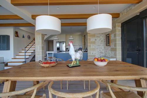 a dining room table with a chicken on top of it at Villa Simera, with pool & great view in Fournádhos