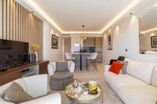 un salon avec un canapé blanc et une télévision dans l'établissement Appartements Croisette Grand Hôtel, à Cannes