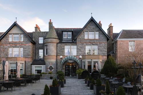 an old building with tables and chairs in front of it at Malmaison Aberdeen in Aberdeen