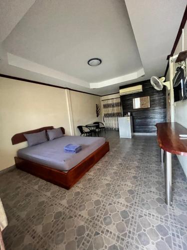 a bedroom with a bed and a table in it at Baanpuklertsuk in Ban Map Ta Put