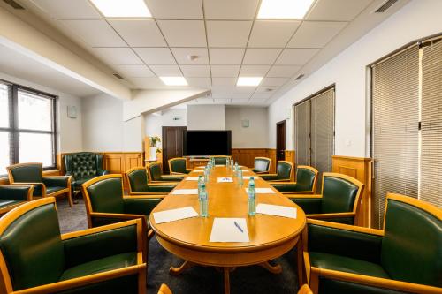 a conference room with a long table and green chairs at Grand Hotel Velingrad in Velingrad