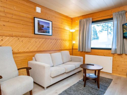 un salon avec un canapé blanc et une table dans l'établissement Holiday Home Huhmari 17 by Interhome, à Polvijärvi