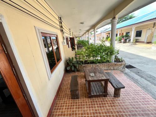 a wooden bench sitting on the side of a building at Baanpuklertsuk in Ban Map Ta Put