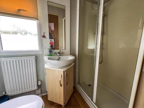 ein Badezimmer mit Dusche, Waschbecken und Toilette in der Unterkunft Dog Friendly 8 Berth Caravan At Dovercourt Holiday Park In Essex Ref 44504P in Great Oakley