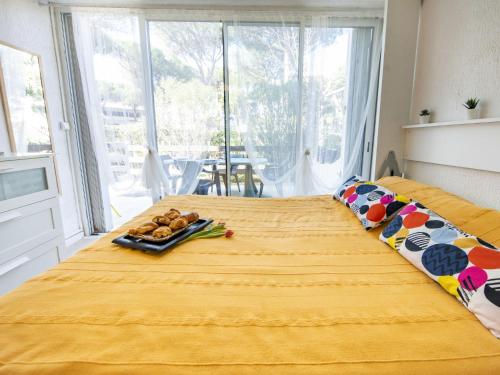 - un lit jaune avec un plateau de nourriture dans l'établissement Studio Holiday 34 by Interhome, à La Grande Motte