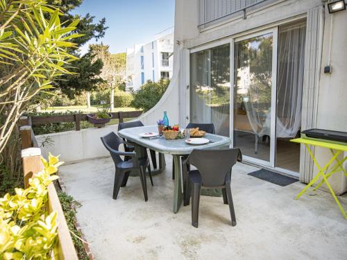 un patio avec une table et des chaises sur un balcon dans l'établissement Studio Holiday 34 by Interhome, à La Grande Motte