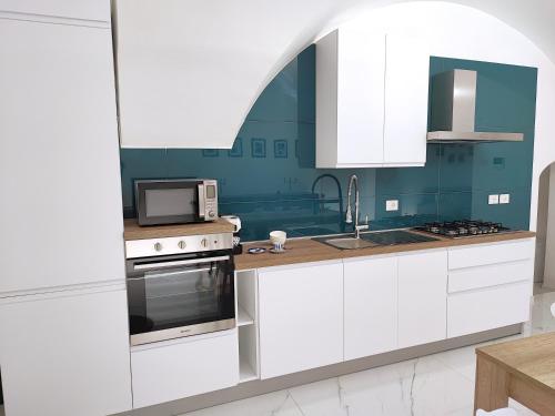 a kitchen with white cabinets and a microwave at LianHome b&b "Volte" in Lucera