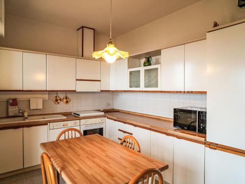 シルヴィ・マリーナにあるApartment Silvi Marina Vista Mare 1 by Interhomeの白いキャビネットと木製のテーブルのあるキッチン