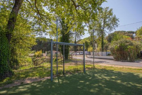 a batting cage in a park with a tree at Mobilhome Puget-sur-argens in Puget-sur Argens