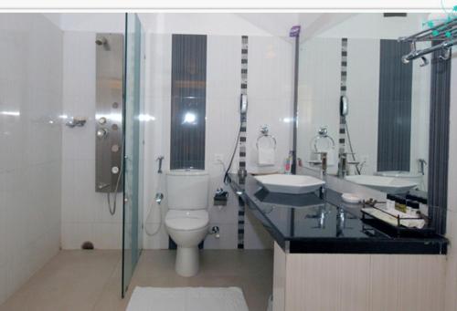 ein Bad mit einem WC, einem Waschbecken und einer Dusche in der Unterkunft The New Marrion in Bhubaneshwar