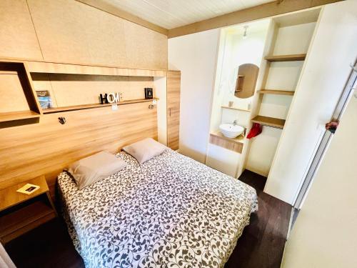 une petite chambre avec un lit et un lavabo dans l'établissement Chalet V tout confort proche des plages, à Pianottoli-Caldarello