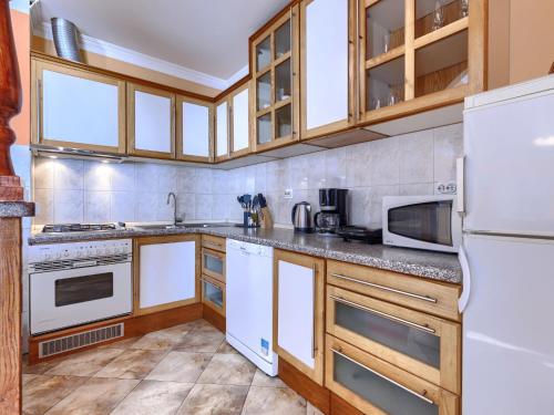 a kitchen with white appliances and wooden cabinets at Holiday Home Soriso by Interhome in Motovun