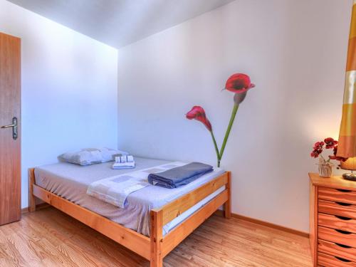 a bedroom with a bed with a vase of flowers on it at Holiday Home Soriso by Interhome in Motovun