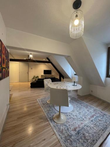 - un salon mansardé avec une table et un canapé dans l'établissement Arènes 2 à deux pas du centre historique, à Besançon