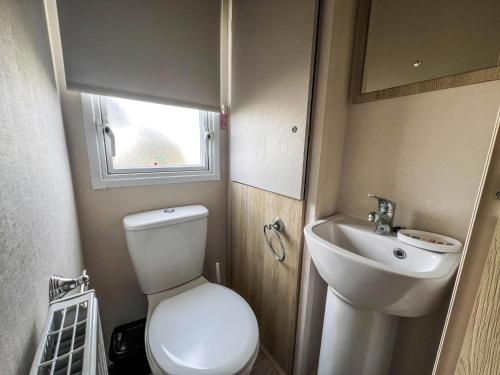 a small bathroom with a toilet and a sink at Great Caravan With Modern Furnishings At Dovercourt Holiday Park Ref 44007D in Great Oakley