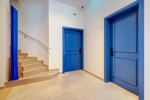 an empty hallway with blue doors and stairs at Kirxa Rooms and Suites in Sliema