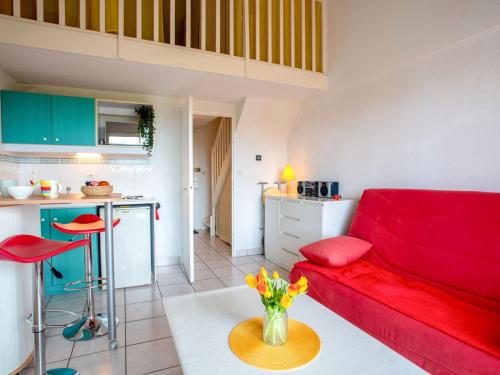 un salon avec un canapé rouge et une cuisine dans l'établissement Apartment L'Orée du Golf-2 by Interhome, à Pornic