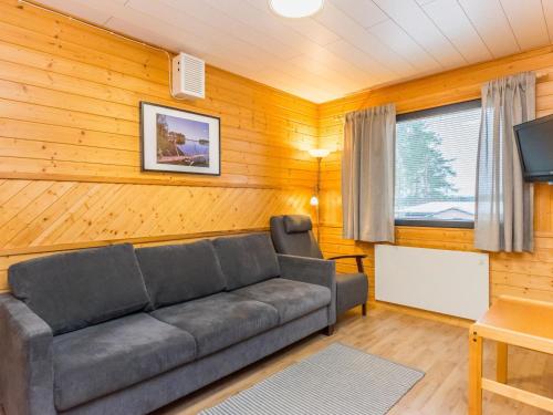 un salon avec un canapé et une télévision dans l'établissement Holiday Home Huhmari 12 by Interhome, à Polvijärvi