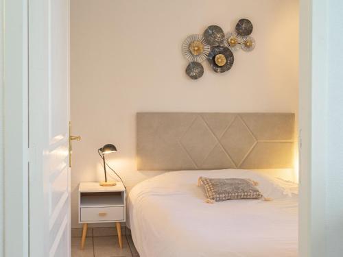 a bedroom with a bed and a clock on the wall at Apartment Jardins de Pontaillac-7 by Interhome in Vaux-sur-Mer