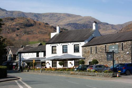 a building on the side of a street with mountains at The Crown Inn in Coniston