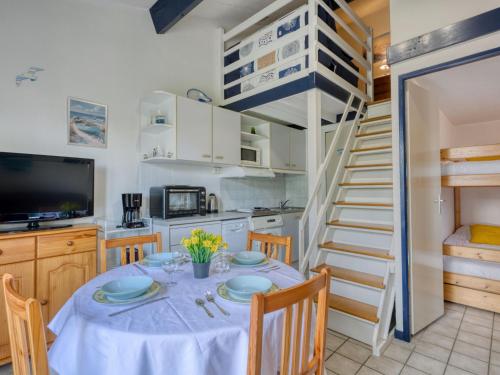 une cuisine et une salle à manger avec une table et un escalier en colimaçon dans l'établissement Holiday Home Hameau de Talaris-18 by Interhome, à La Palmyre