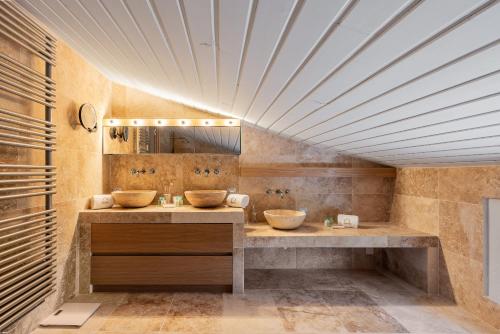 La salle de bains est pourvue de 2 lavabos et d'un grand plafond. dans l'établissement Le Grand Paradis, à Callas