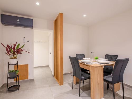 une salle à manger avec une table en bois et des chaises noires dans l'établissement Apartment L'Atalante by Interhome, à Sainte-Maxime