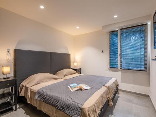 une chambre avec un grand lit et deux fenêtres dans l'établissement Apartment L'Atalante by Interhome, à Sainte-Maxime