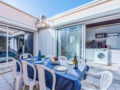 une salle à manger avec une table et des chaises et une cuisine dans l'établissement Holiday Home Les Sirènes by Interhome, au Barcarès