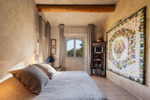 - une chambre avec un lit et une grande tapisserie sur le mur dans l'établissement Le Grand Paradis, à Callas