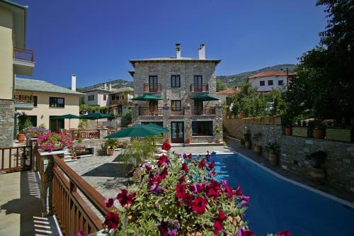 ポルタリアにあるMaritsas Hotel & Suitesの花の咲くスイミングプールと建物を併設するリゾート