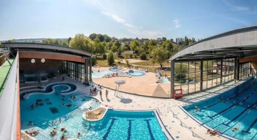 une grande piscine à côté d'un immeuble dans l'établissement Le Tilleul, au coeur du centre historique, à Lons-le-Saunier