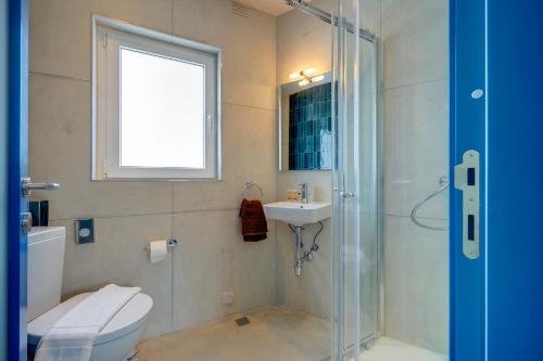 a bathroom with a shower and a toilet and a sink at Kirxa Rooms and Suites in Sliema