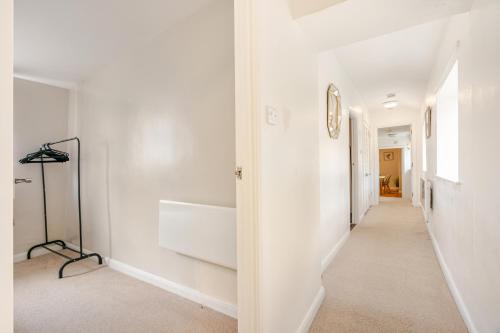 a hallway with white walls and a long white hallway at Hummingbird House in Cockermouth