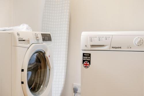 a white washing machine next to a white refrigerator at Hummingbird House in Cockermouth