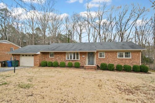 a home with a brick house with a driveway at Cozy 3BR Ranch in Durham in Durham