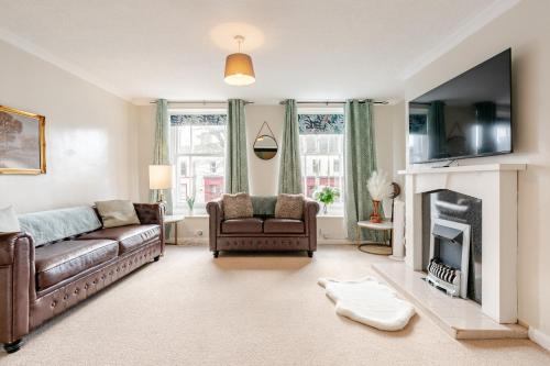 a living room with a couch and a fireplace at Hummingbird House in Cockermouth