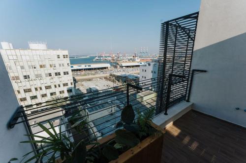 a balcony with plants and a view of a city at Communit Penthhous - Urban Vacation & Port View in Haifa