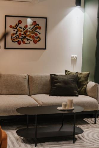 a living room with a couch and a table at Communit Penthhous - Urban Vacation & Port View in Haifa
