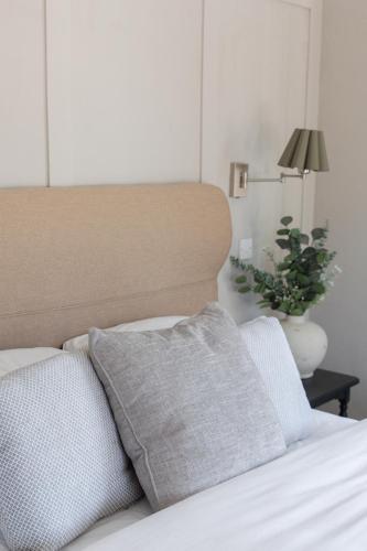 a bed with two pillows and a lamp and a plant at #4 - King Room at The Raven Aparthotel by PureStay in Much Wenlock