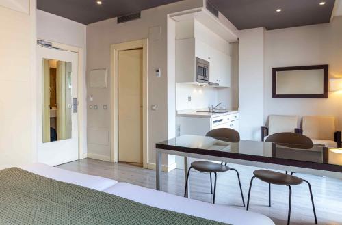 a bedroom with a table and chairs in a room at Suites Viena Plaza de España in Madrid