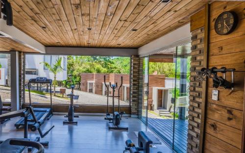 an indoor gym with a large window and gym equipment at Pousada Natribus Rosa in Praia do Rosa