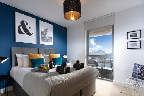 a bedroom with a large bed with blue walls at Plymouth Penthouse Apartment-Sea View-Sleeps 7- Habita Property in Plymouth