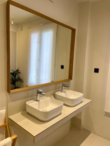 a bathroom with two sinks and a large mirror at Apartamentos Concepcion in Albacete