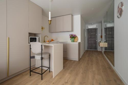 a kitchen with white cabinets and a counter at "M&D ApartmentsLviv", Loft complex Great Britain in Lviv
