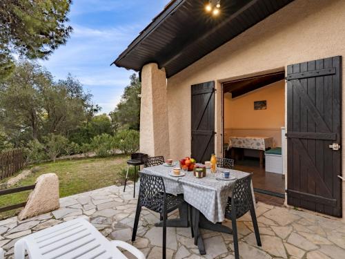 un patio avec une table et des chaises sur un patio dans l'établissement Holiday Home Casa Tarco by Interhome, à Bonifacio