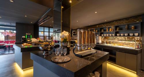 a restaurant with a bar with glasses on a counter at PLAZA Premium Parkhotel Neu-Ulm in Ulm