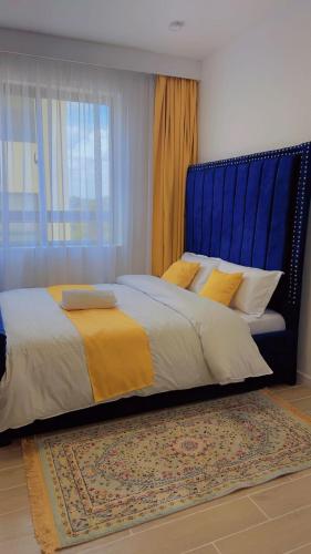 a bedroom with a large bed with a blue headboard at Kozy Homes in Nairobi